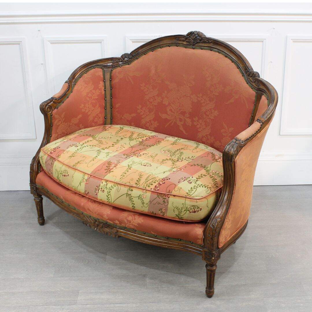 curved settee with carved wooden frame